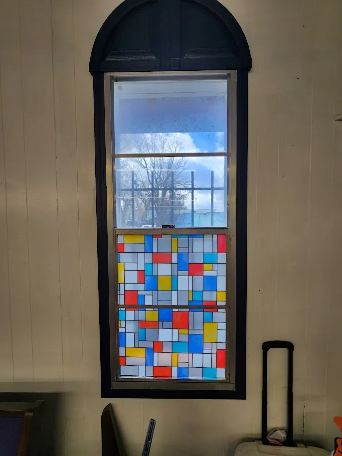 Interior view looking out toward trees and homes through windows treated with residential solar control window film tinting installed by Valion Tinting for energy savings in Kansas City